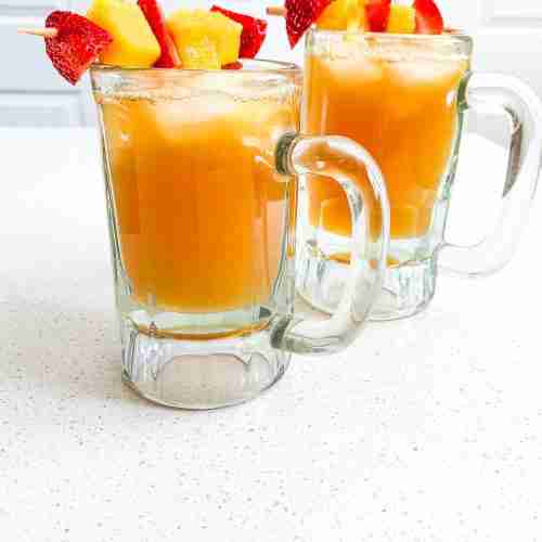 2 iced teas on a counter with a fruit kabob garnish