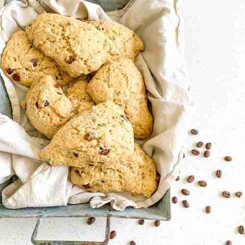 scones in a basket with coffee beans beside it