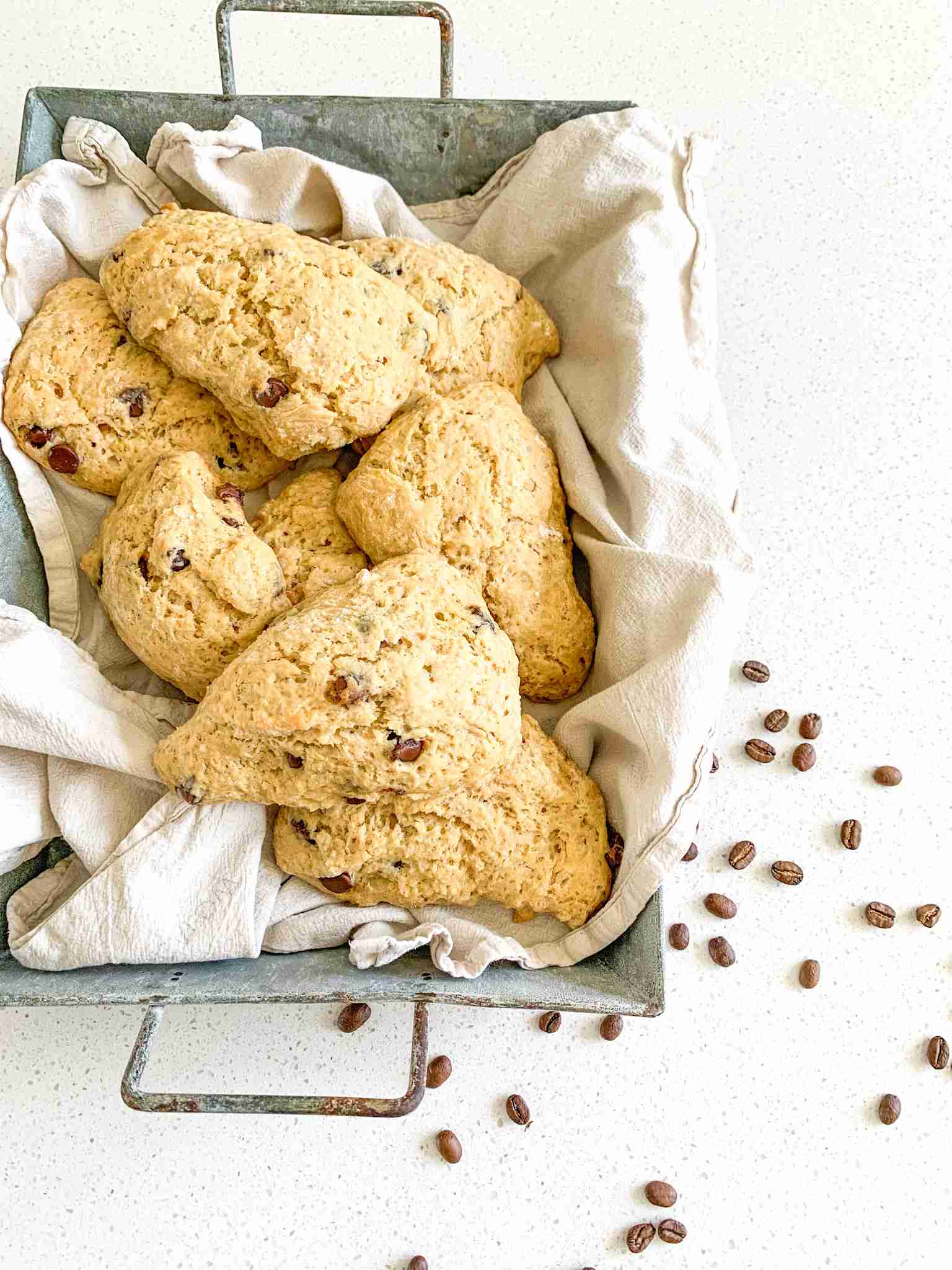 scones in a basket with coffee beans beside it