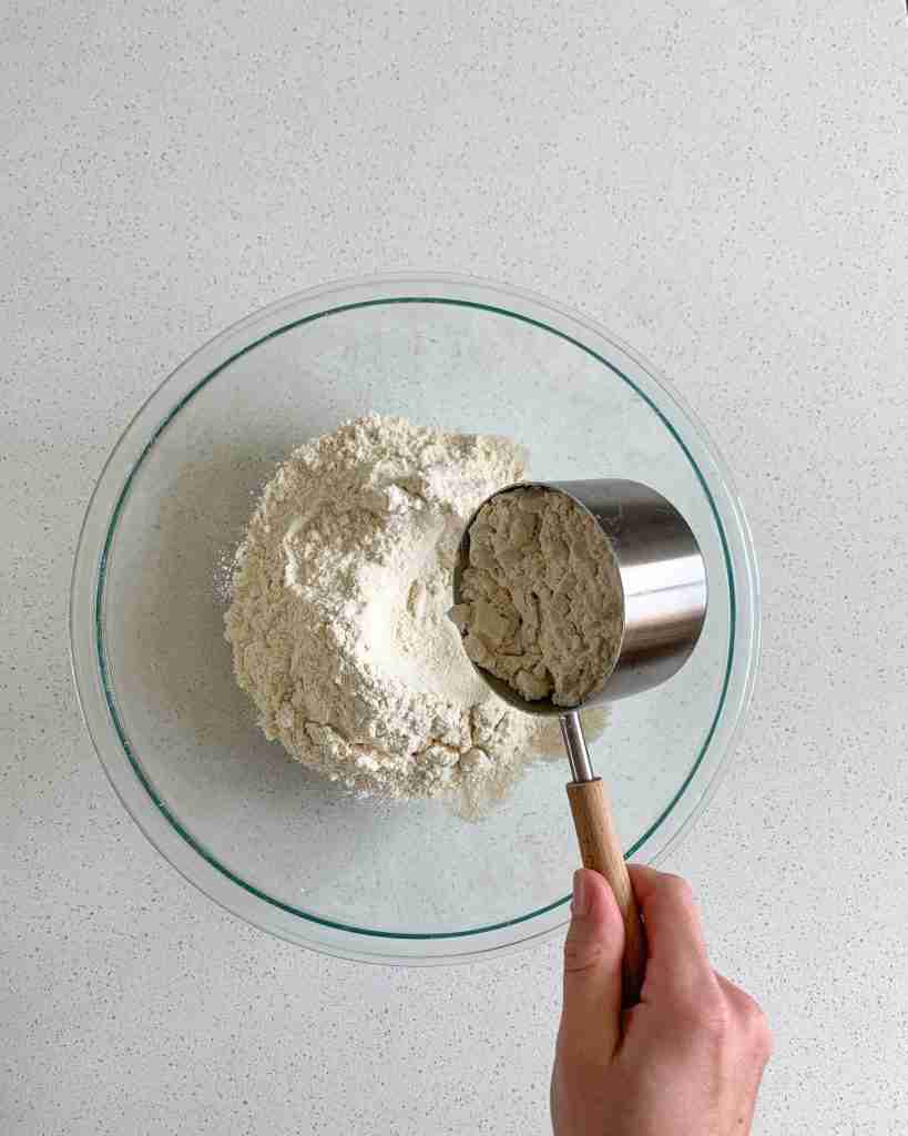 adding dry ingredients into a mixing bowl