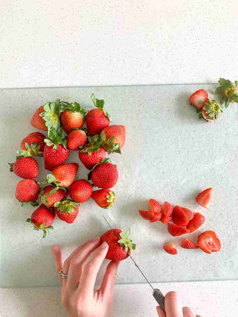 hands slicing strawberries