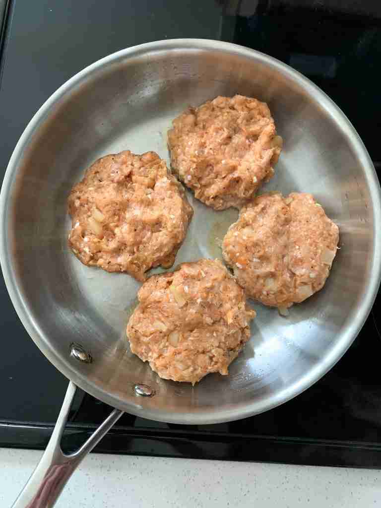 4 burgers in a pan on the stovetop