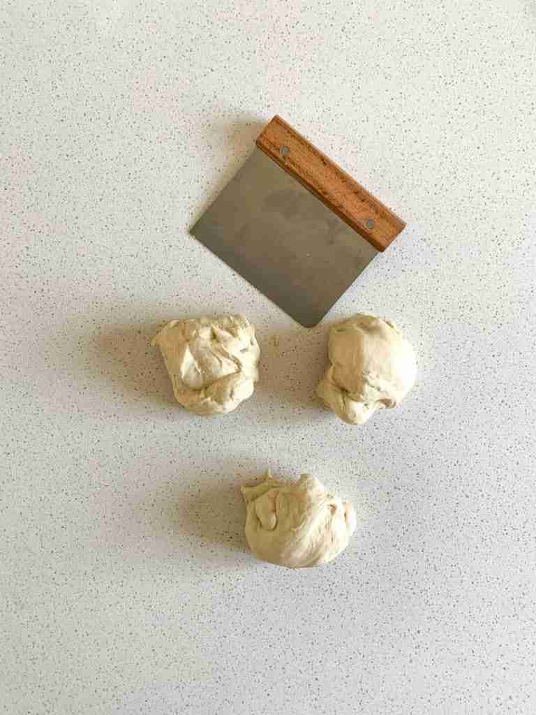 3 pieces of dough and a dough scraper that cut them