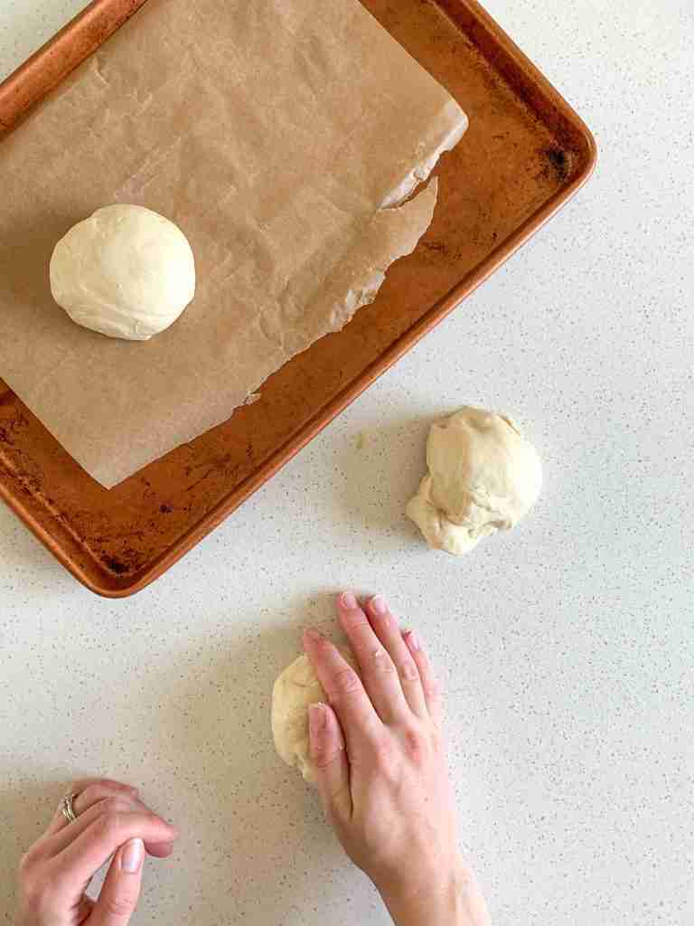 hands shaping sourdough hamburger buns 