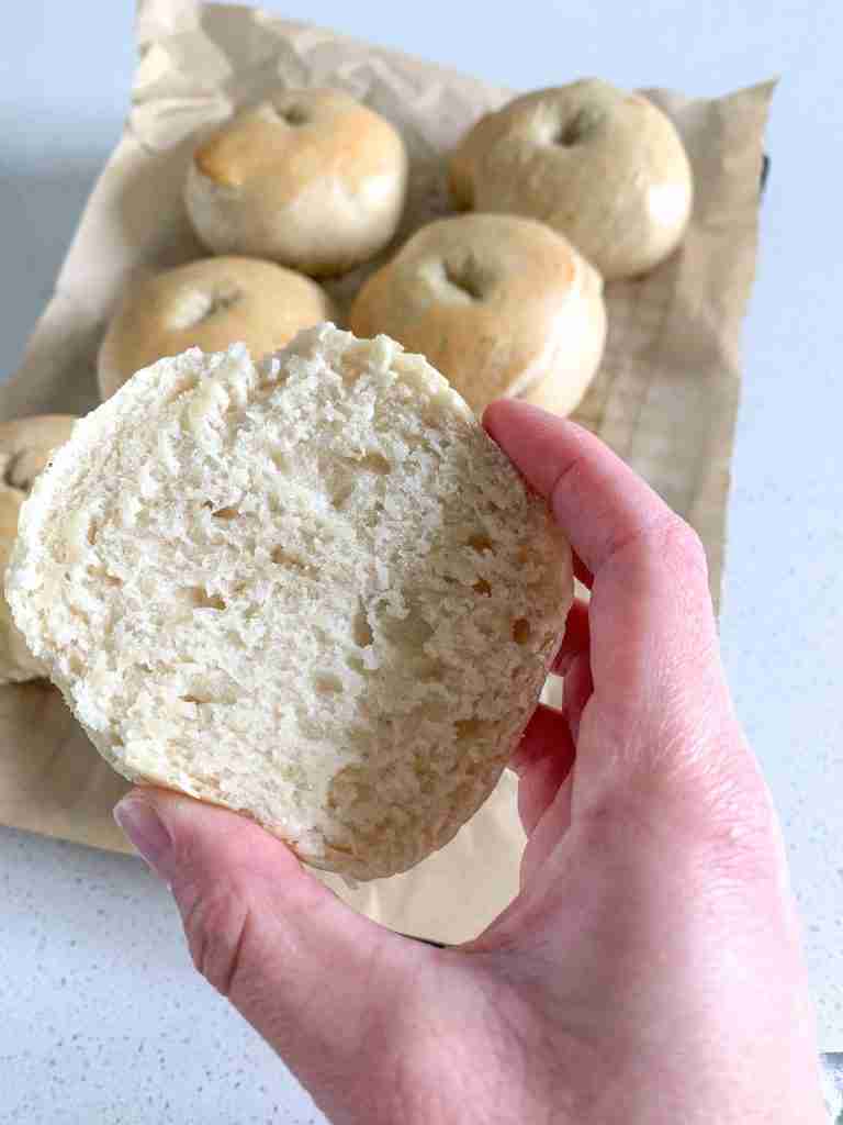 bagel cut open with a hand holding it