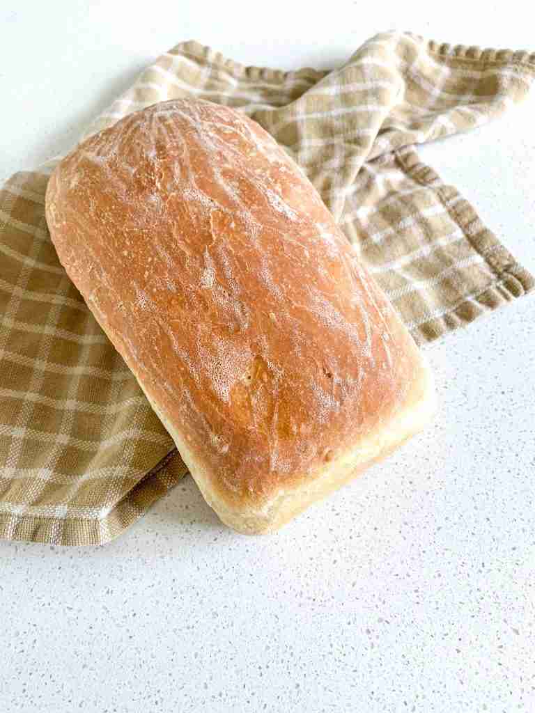 loaf of bread sitting on a towel on the counter