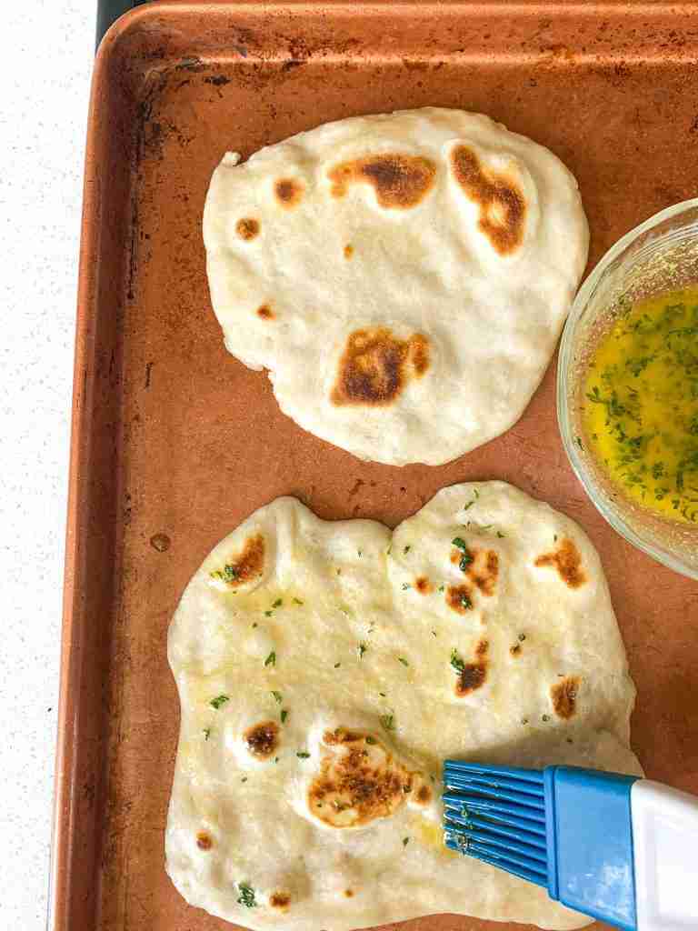 brushing butter herbs on bread