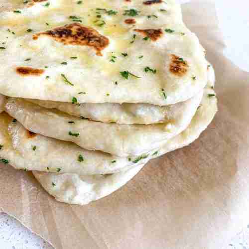 stack of flattened breads on parchment paper