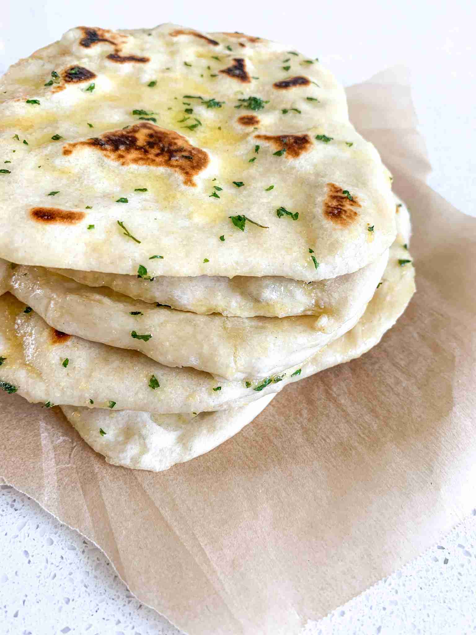 stack of flattened breads on parchment paper