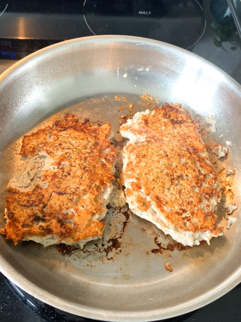 cooking chicken burgers in a pan