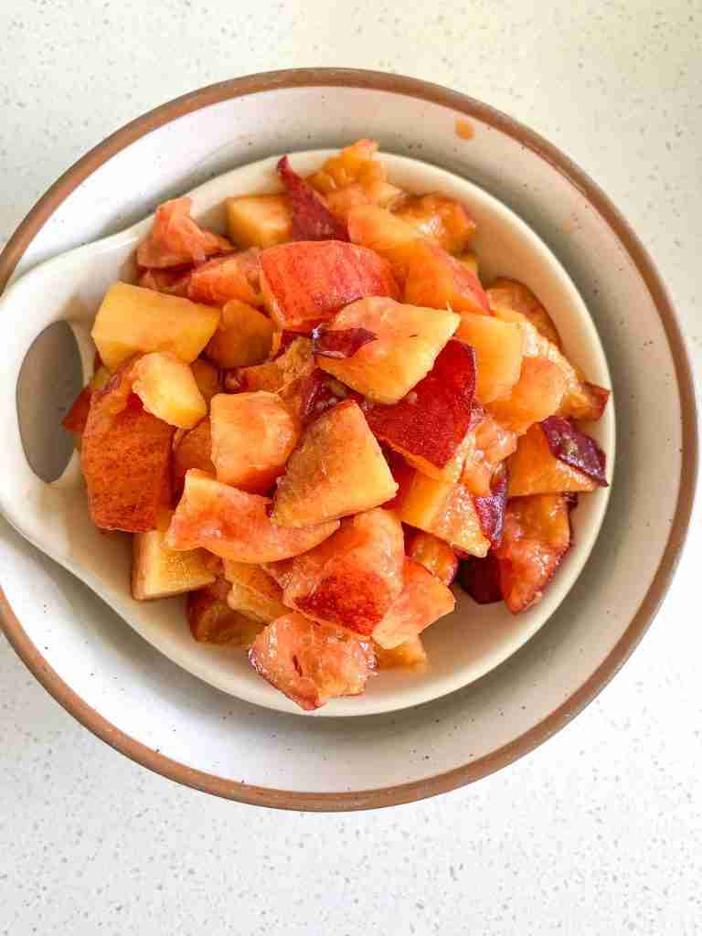 peach chunks in a strainer over a bowl