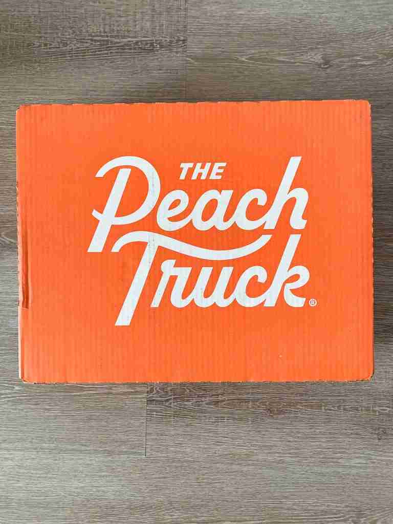 The Peach Truck's orange box full of peaches