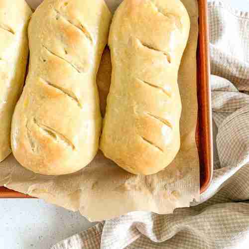 buns sitting on a sheet pan on top of a towel