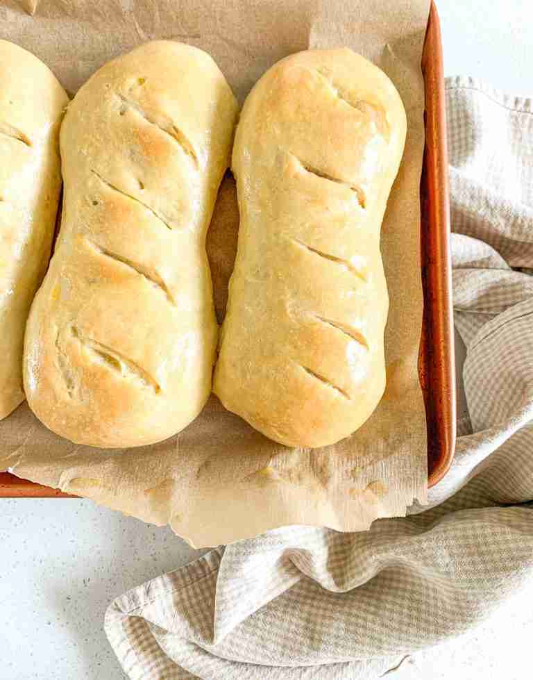 buns sitting on a sheet pan on top of a towel
