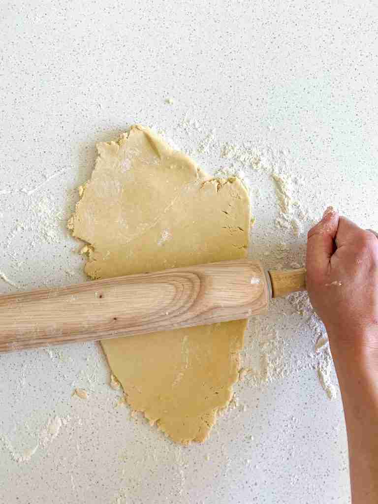 hand rolling out cookie dough