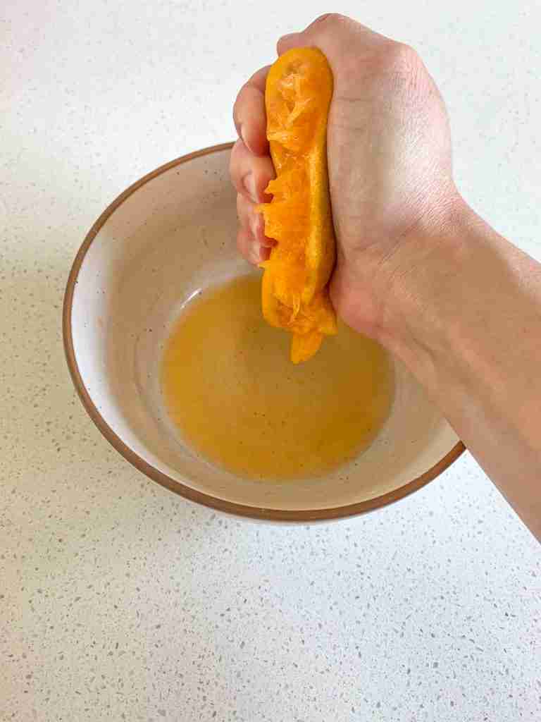 hand squeezing an orange