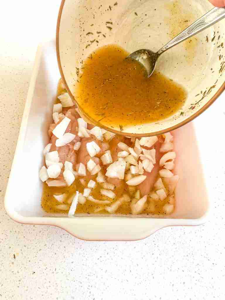 pouring marinade over chicken 