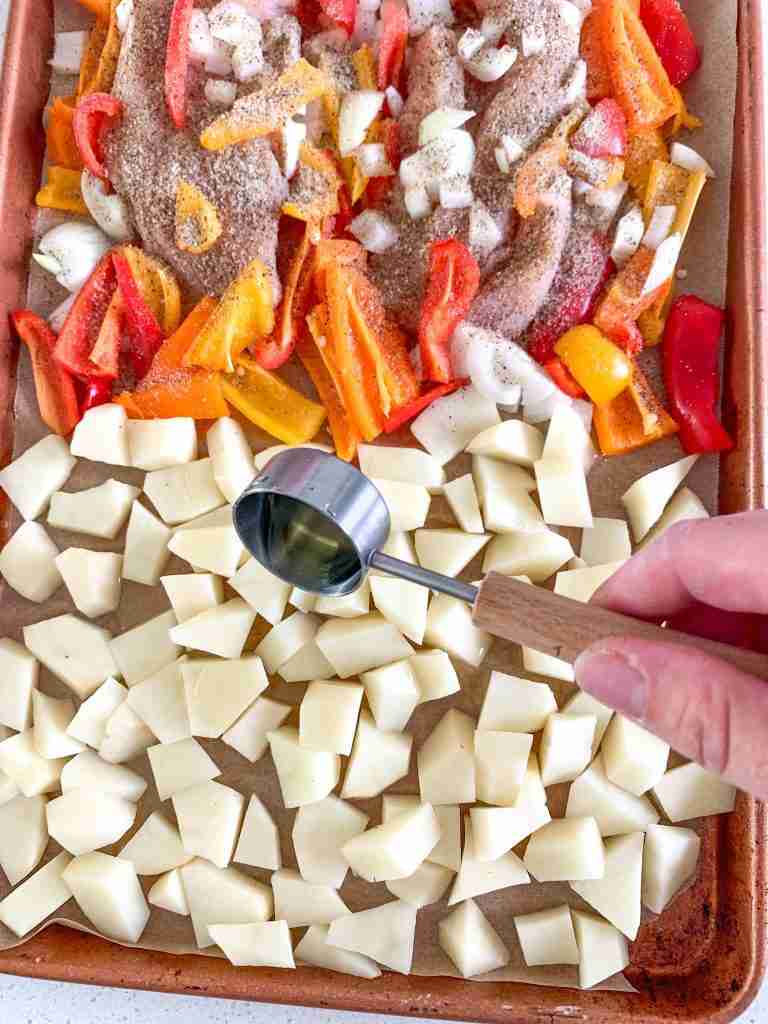 hand adding avocado oil to potatoes