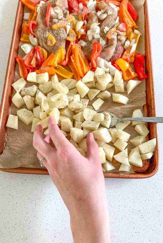 hands stirring potatoes with seasoning