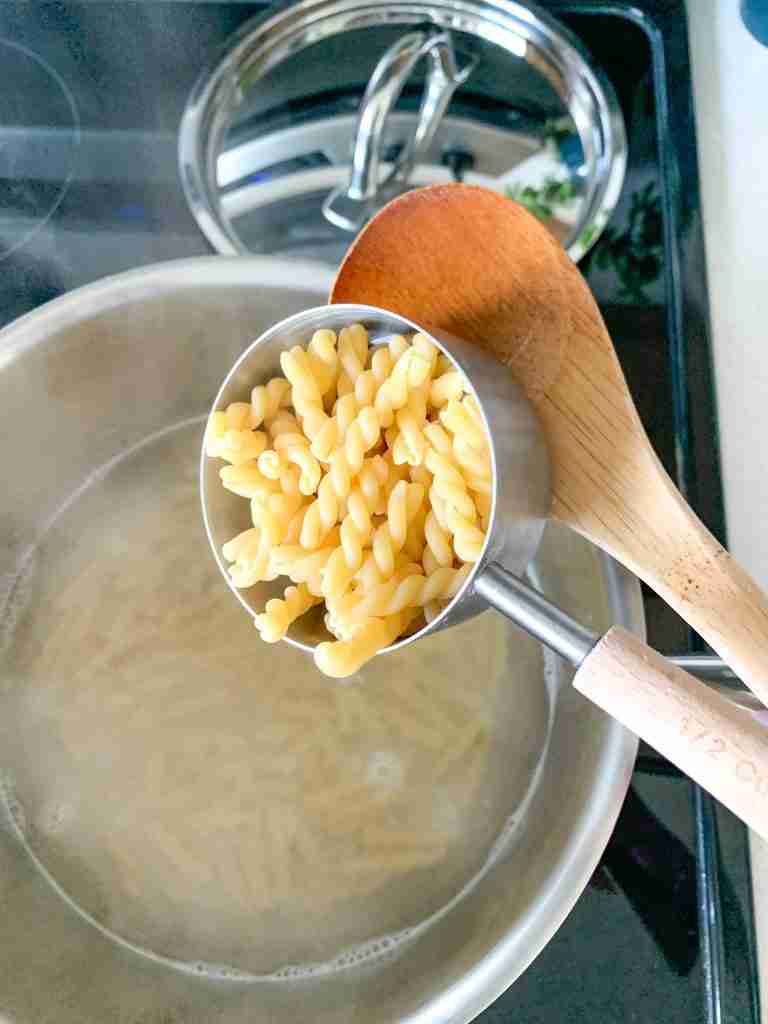 pasta getting poured into a boiling water pot