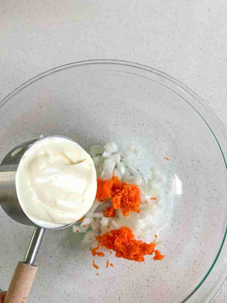 mayo getting poured into carrots and onions