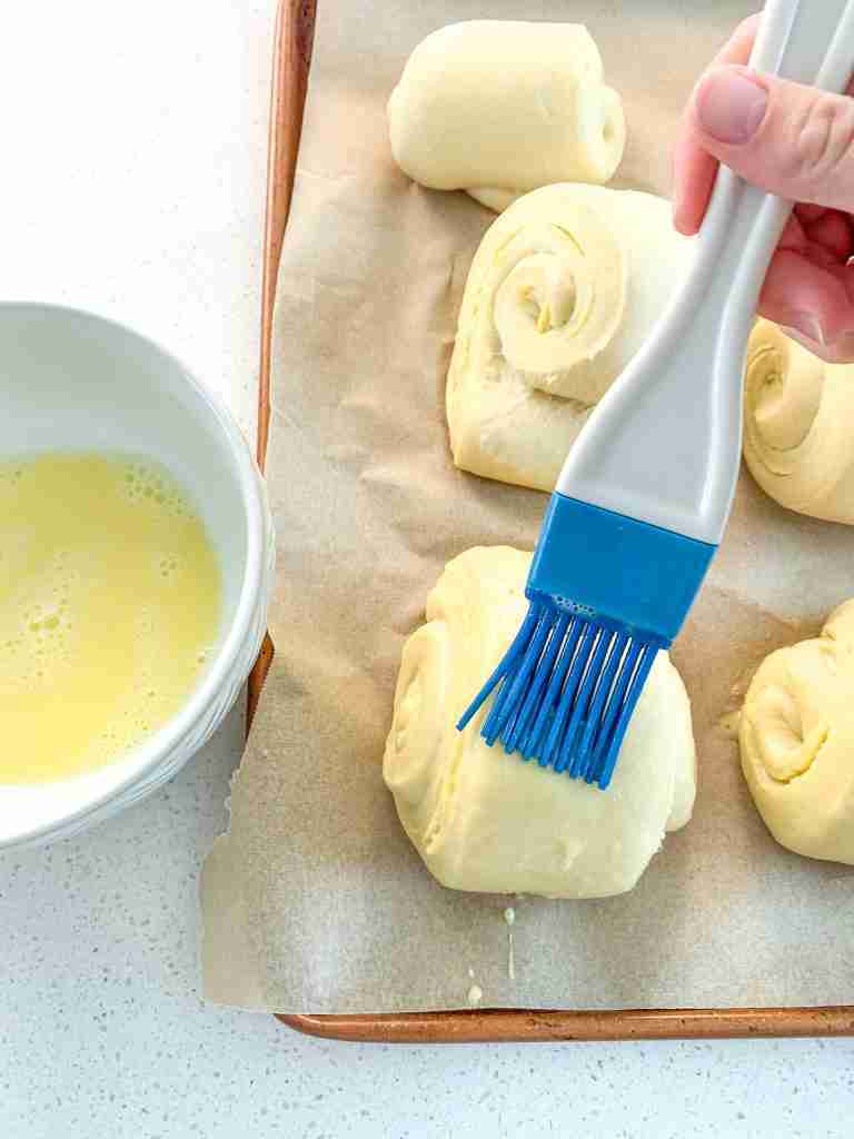 brushing shaped and proofed croissants with egg wash