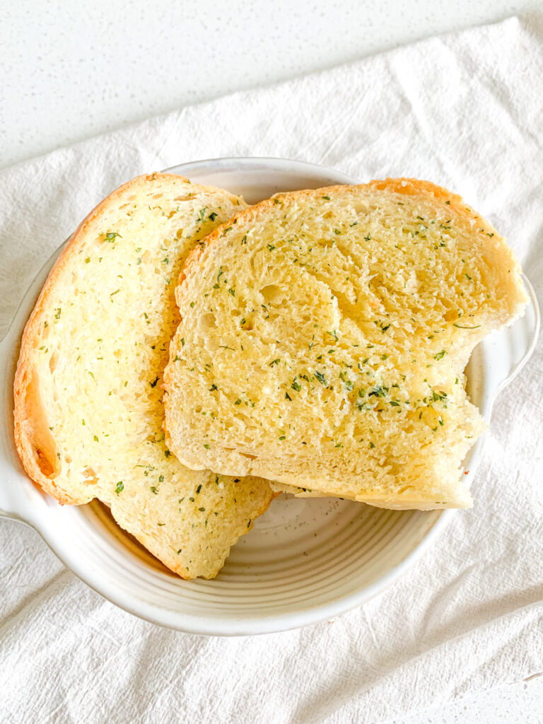 freshly made sourdough garlic bread with a bite taken out
