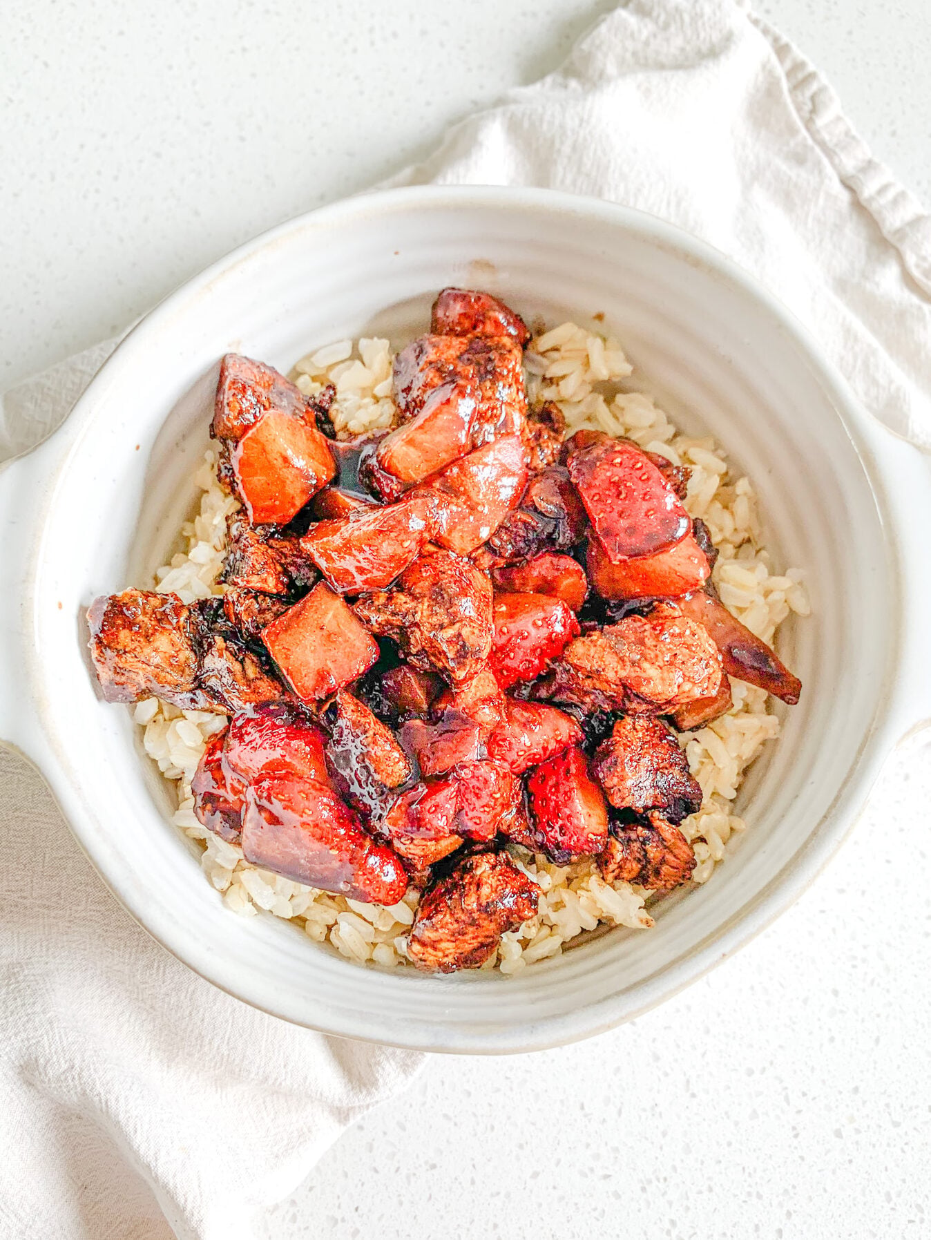 freshly made pan-seared balsamic strawberry chicken bites on a bed of brown rice