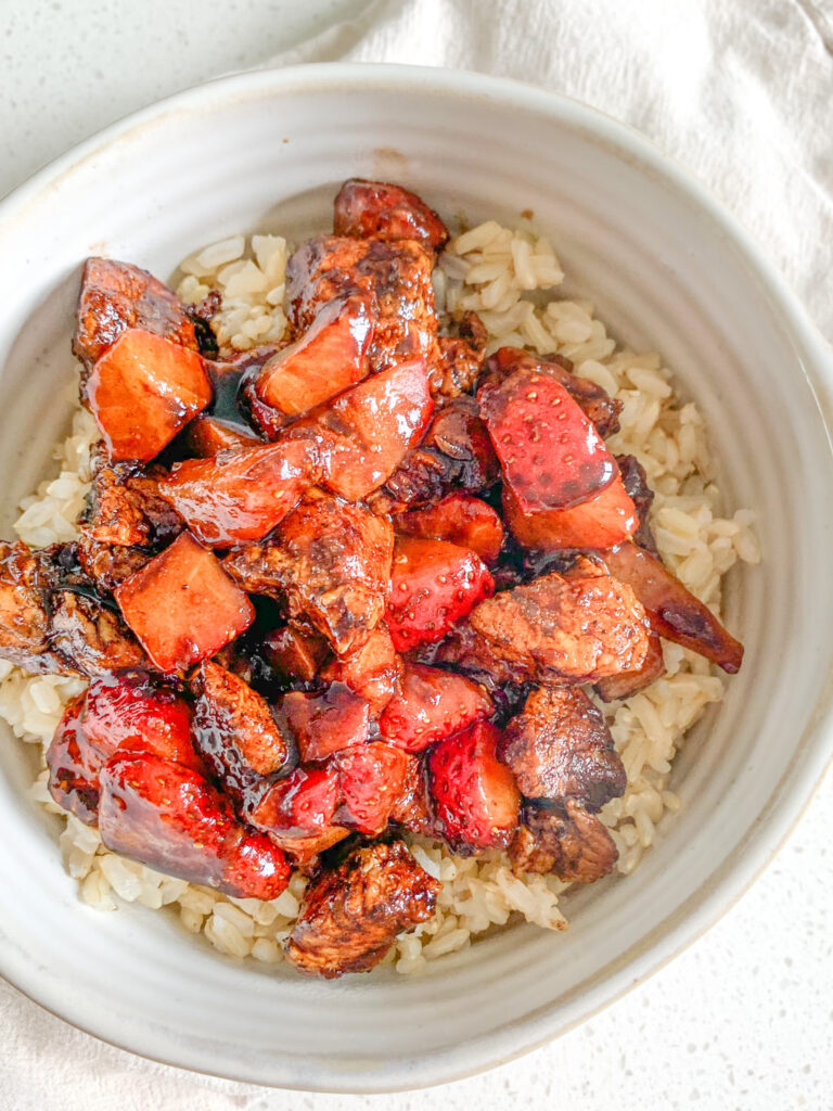 freshly made pan-seared balsamic strawberry chicken bites on a bed of brown rice