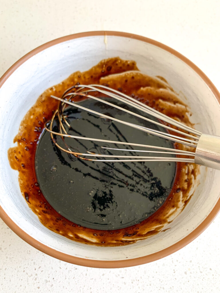whisking together homemade balsamic dressing
