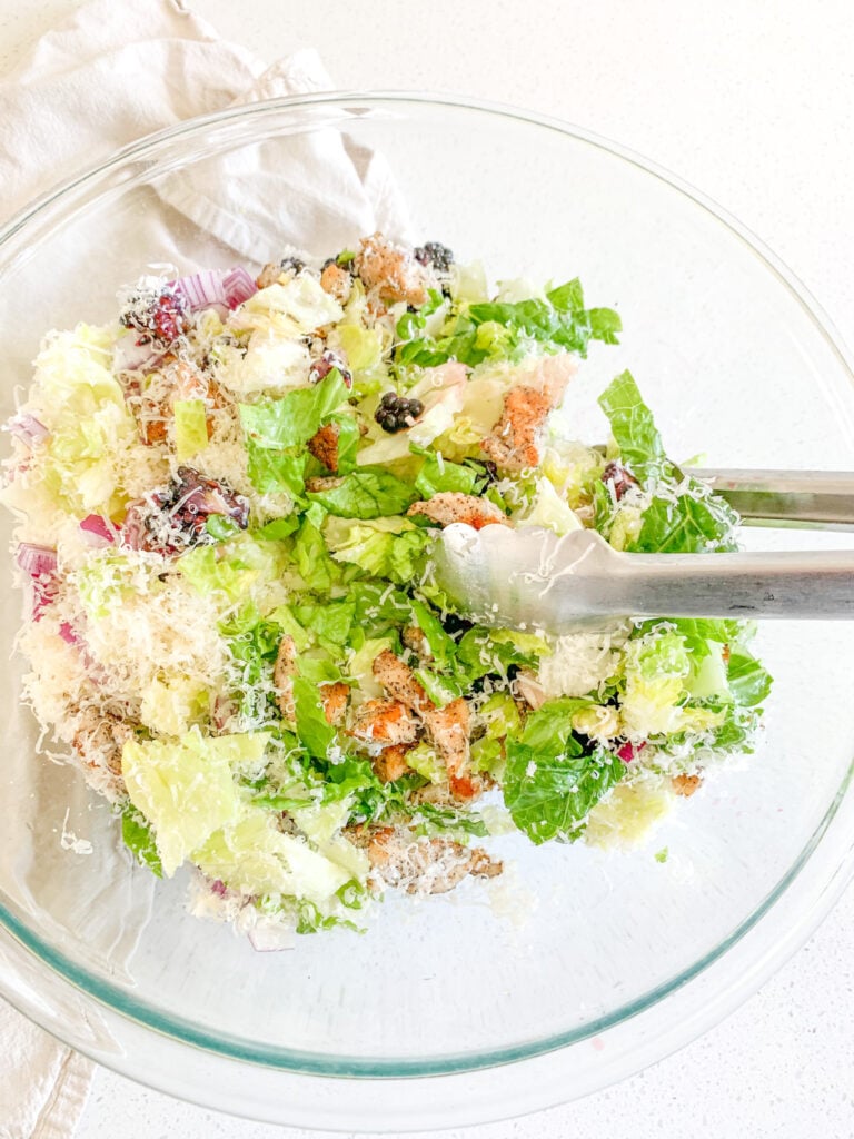 tossing salad ingredients together