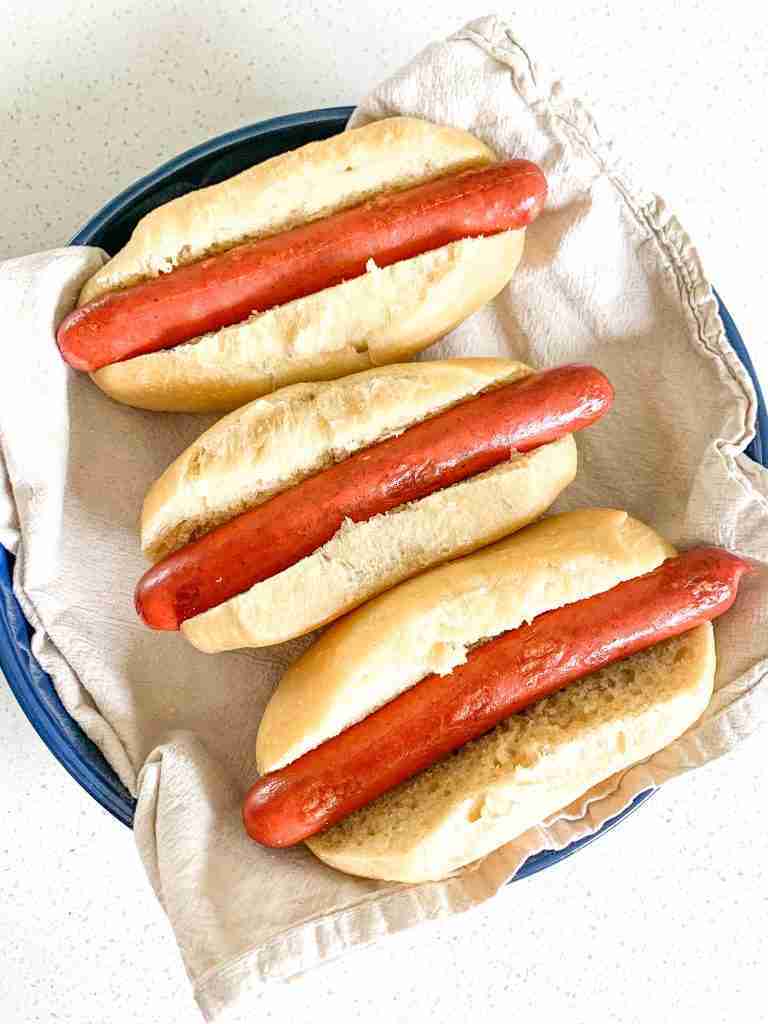 overhead shot of hot dogs in buns in a try