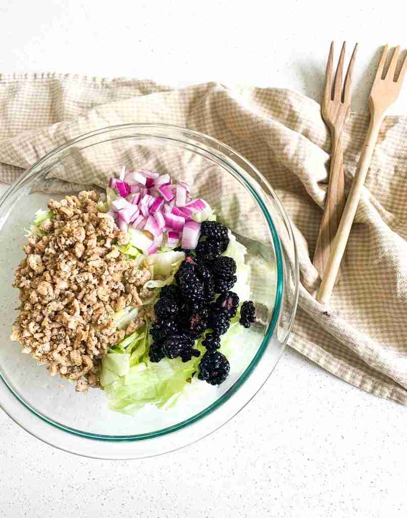 salad setup with tossing forks beside it on the counter