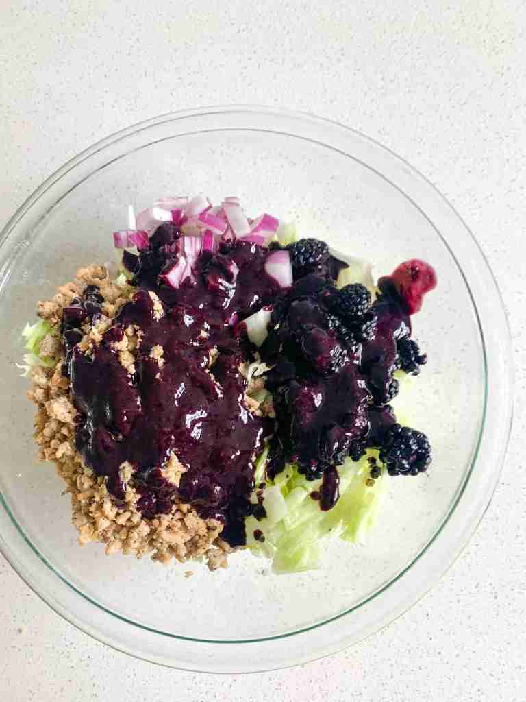 bowl of salad covered in a blackberry dressing