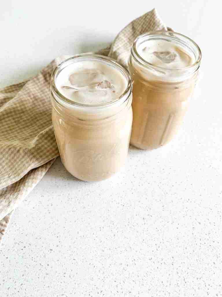 2 iced drinks sitting on the counter with a towel behind them
