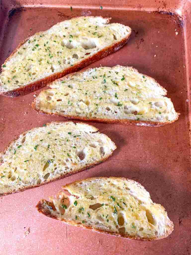 slices of garlic bread on a sheet pan