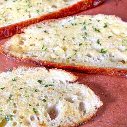 slices of garlic bread on a sheet pan