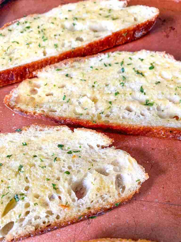 slices of garlic bread on a sheet pan