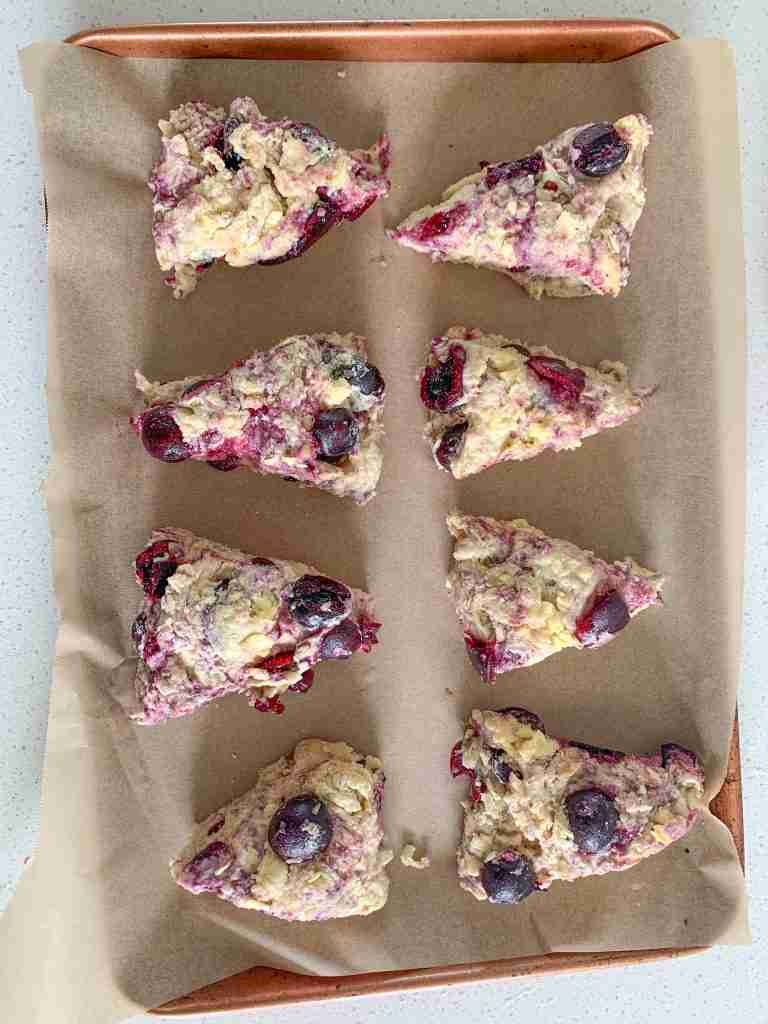 unbaked cherry scones on a baking sheet waiting to be baked