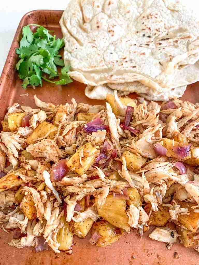 shredded taco chicken and tortillas on a sheet pan
