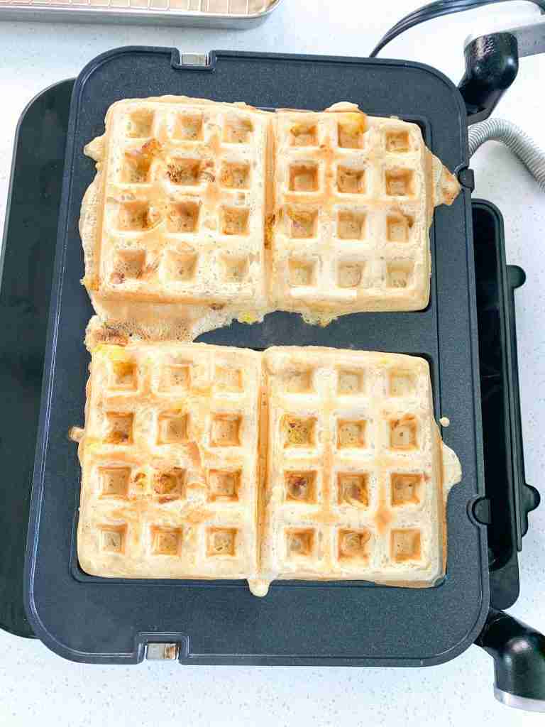 peach waffles cooking on a waffle maker