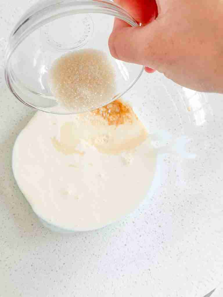 adding whipped cream ingredients into a bowl