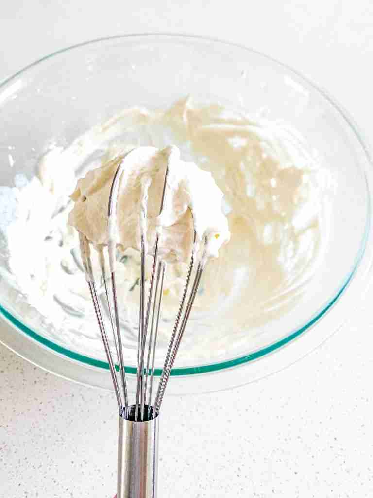 freshly made homemade whipped cream on a whisk