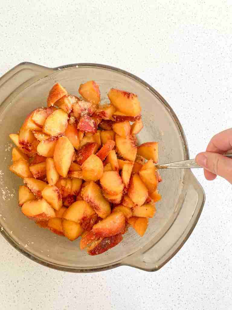 peaches getting stirred in a bowl