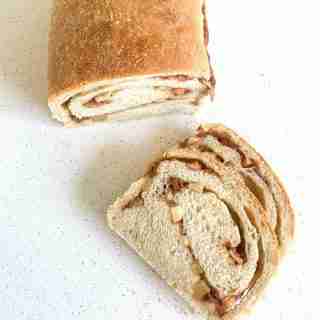 loaf of sourdough apple bread with a few slices laying beside it