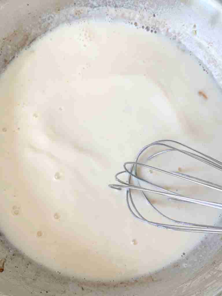 whisking milk into roux