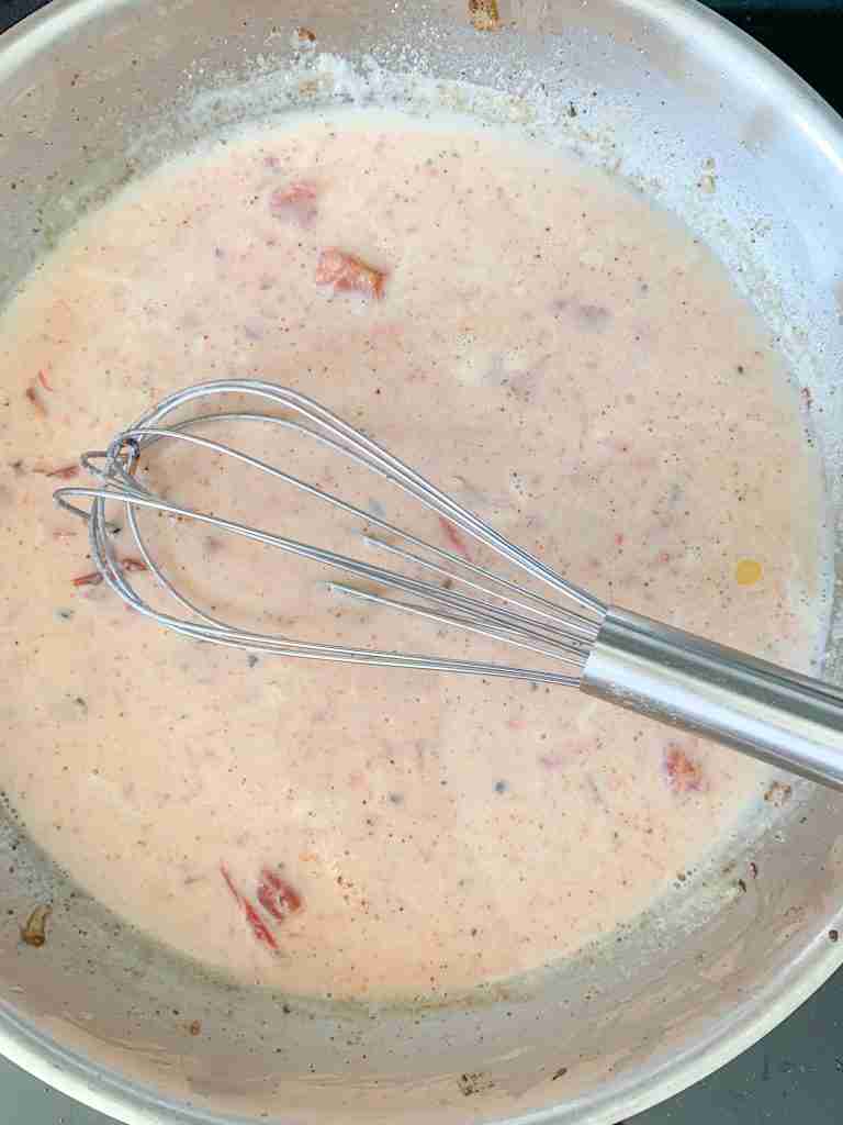whisking tomatoes into the milk mixture