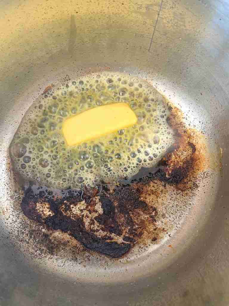 adding butter into the pan and melting it