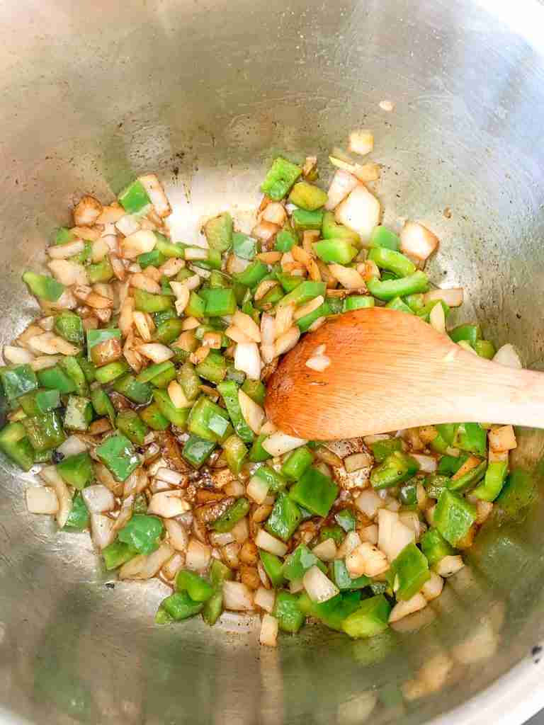 cooking onion and peppers in a pan