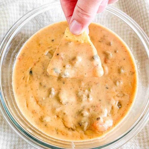 hand dipping a chip into homemade rotel dip